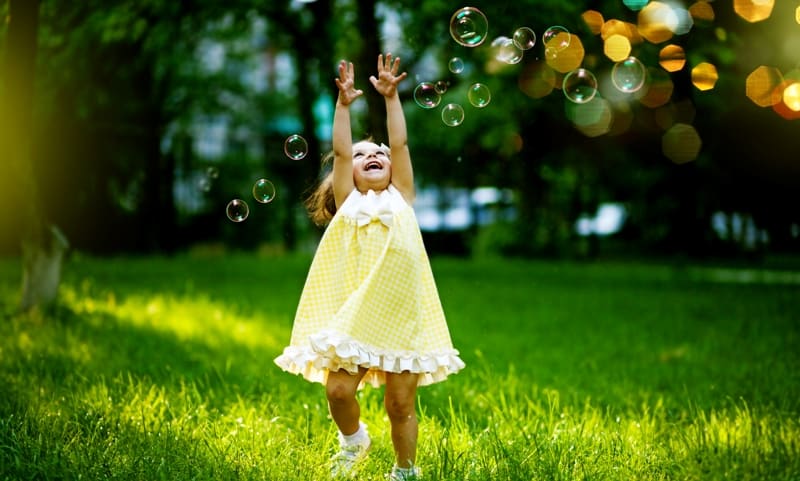 Girl playing with bubbles - blowing bubbles picnic game for kids