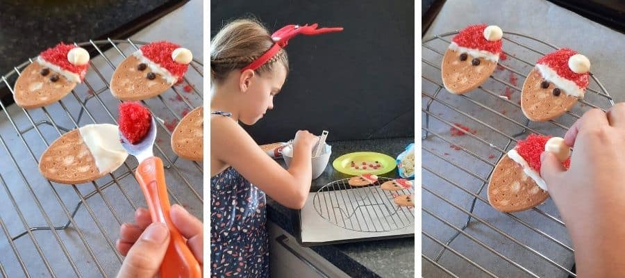 Girl busy decorating Santa Christmas cookies