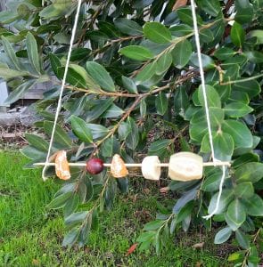 Picnic Crafts: a homemade bird feeder made out of a kebab stick, strings and pieces of food