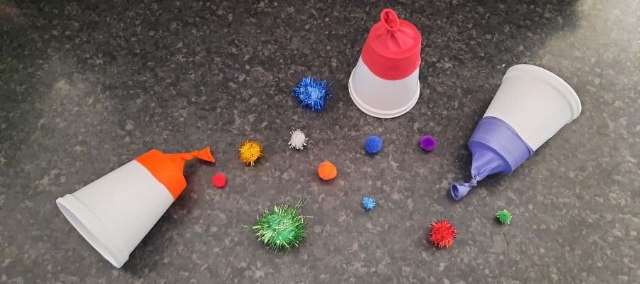Pom pom shooters made from paper cups and balloons. Fun picnic crafts for preschoolers